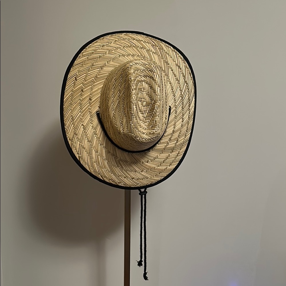 Stylish straw hat by David and Young. Features black trim and chin strap.